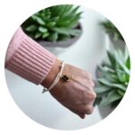 Veterarmband wit met zwart klavertje goud