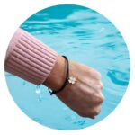 Veterarmband zwart met wit klavertje goud