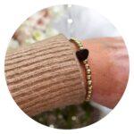 Armband gouden kraaltjes en zwart hartje