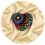 Houten hartje met dot painting op een beide zijden gedrapeerd laken.