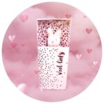 Konijn knuffel in een doosje met de tekst 'Veel Liefs' tegen een roze achtergrond met hartjes