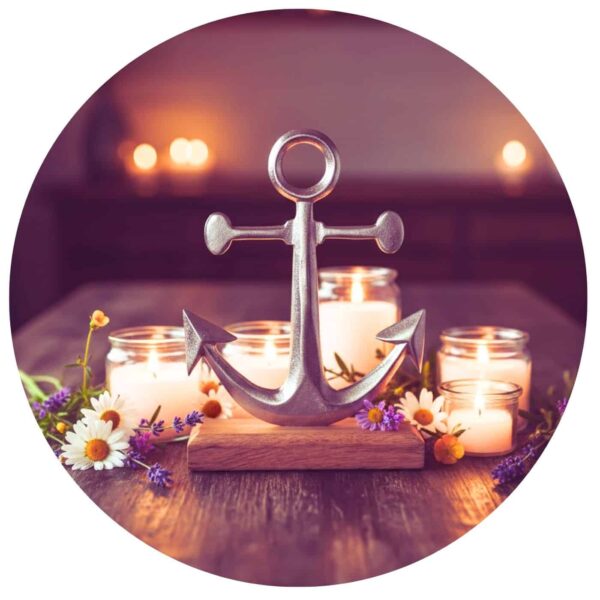 Metalen anker op houten voet omringd door kaarsen