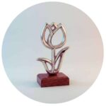 metalen tulp op houten voetstuk effen achtergrond